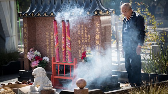 Burning incense in front of the newly constructed memorial at Fawkner cemetery during Qingming. 