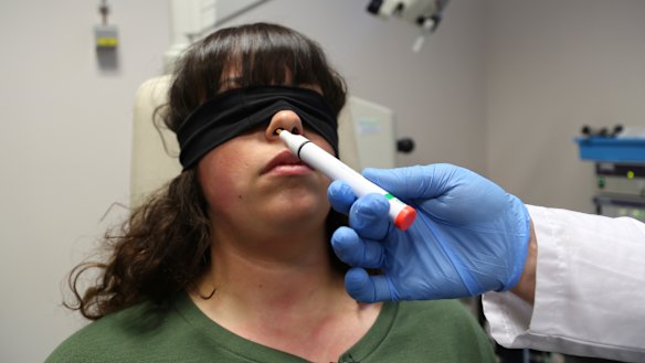 The hand of Dr Clair Vandersteen wafts a tube of odours under the nose of a blindfolded patient, Gabriella Forgione, during tests in a hospital in Nice to help determine why she has been unable to smell or taste since she contracted COVID-19.
