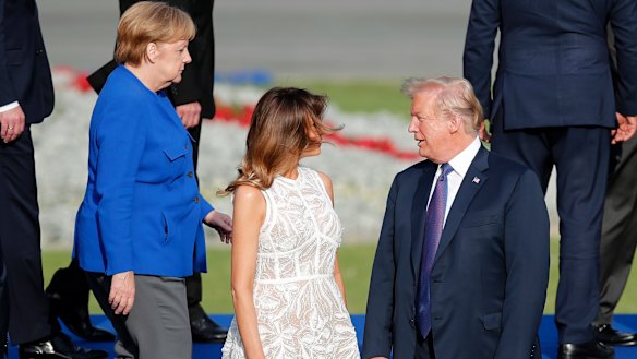 President Donald Trump, first lady Melania and German Chancellor Angela Merkel pose for a group photo of NATO leaders in Brussels.