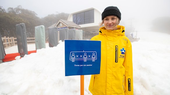 A Mt Buller ski services staff member displays the social-distancing measures the resort was using on its ski lifts.