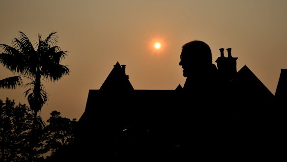 Scott Morrison silhouetted by a smoky sunset over Kirribilli this month. 