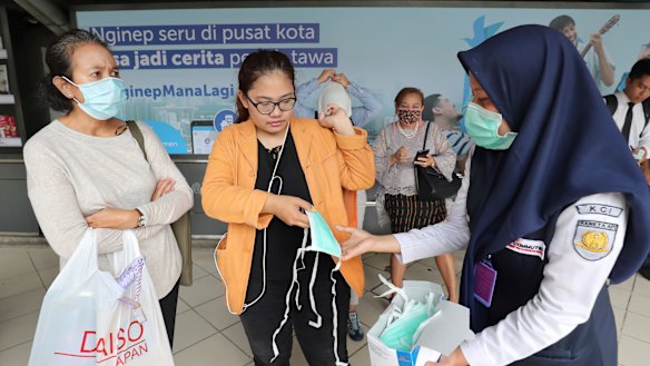 Train officers distributed protective face masks to passengers at a train station in Jakarta, Indonesia. 