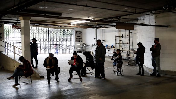 Hospitality workers wait in line in a basement garage to apply for unemployment benefits in Los Angeles.