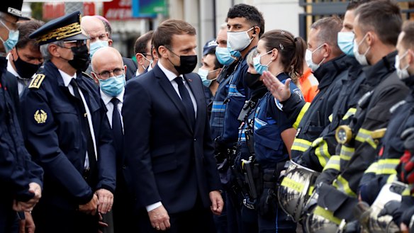 French President Emmanuel Macron meets police and rescue workers outside the cathedral in Nice.