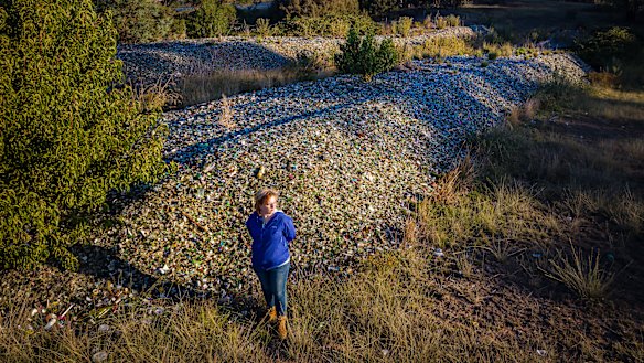 Caitlin Miller with about 900 tonnes of glass she says was dumped on her Bywong property by her father, Garry Miller, without permission. 