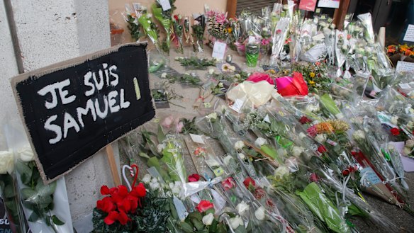 A placard reading "I am Samuel" and flowers lay outside the school where slain history teacher Samuel Paty was working, in Conflans-Sainte-Honorine, north-west of Paris. 
