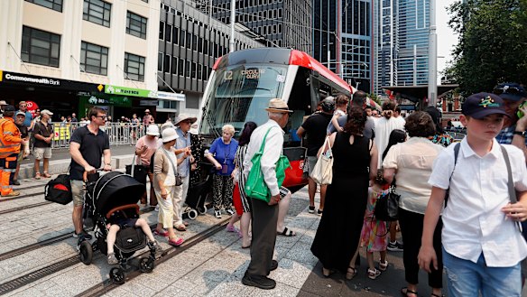 Crowds surround a tram at the Town Hall stop on opening day in December.