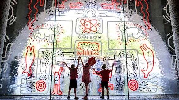 Ferny Creek Primary School students, from left, Archie, Maeve and Reuben check out the recreated mural.