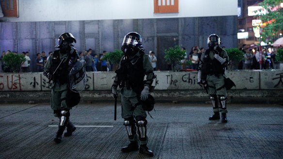 Hong Kong police in anti-riot gear patrol the streets.