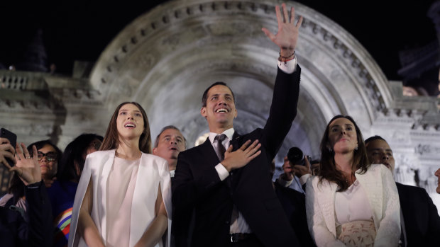 Accompanied by his wife Fabiana Rosales, Venezuela's self-proclaimed interim president Juan Guaido waves to supporters outside the Foreign Ministry in Buenos Aires, Argentina, on Friday.