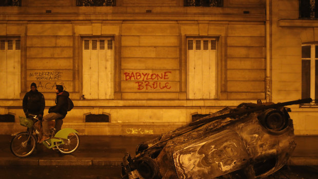 A burned out car and the slogan, "Babylon burns" in Paris on Sunday.
