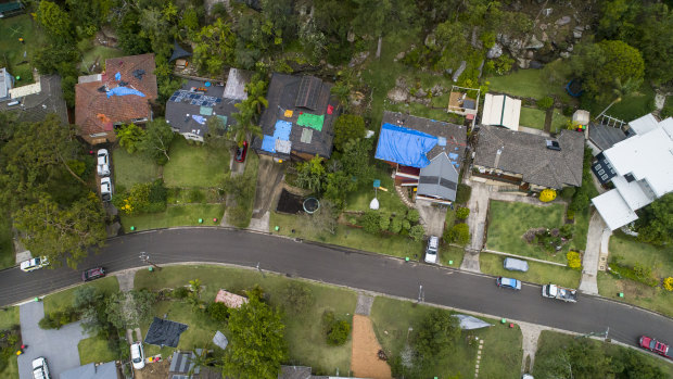 Many homes in Berowra Heights had their roofs covered in tarpaulins on Friday. 