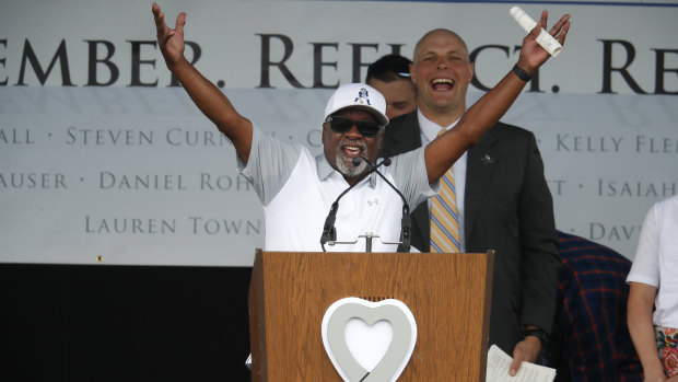 Ivory Moore, a teacher and coach at Columbine High School, leads attendees in a chant for the school during a program for the victims of the massacre at Columbine.