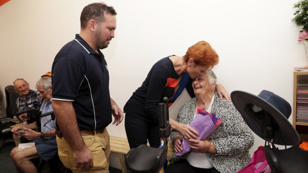 One Nation candidate for Longman, Matthew Stephen and One Nation leader Pauline Hanson present flowers to supporter Barbara Izsolt during Senator Hanson's visit to Caboolture in Queensland on Wednesday.