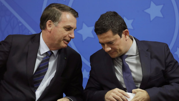 Brazil's President Jair Bolsonaro, left, speaks to his Justice Minister Sergio Moro earlier.