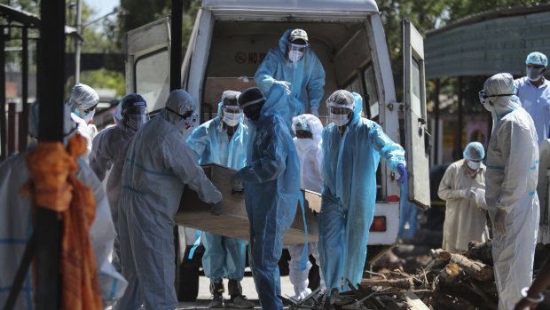 Health workers and relatives carry the body of a COVID-19 victim for cremation in Jammu, India. 