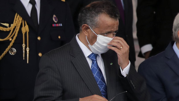 Director General of the World Health Organisation, Tedros Adhanom Ghebreyesus, adjusts a face mask as he attends the Bastille Day military parade, Tuesday, in Paris.