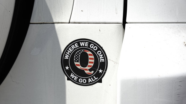 A QAnon bumper sticker is seen on a car outside a campaign rally for US President Donald Trump at Yuma International Airport in Yuma, Arizona.