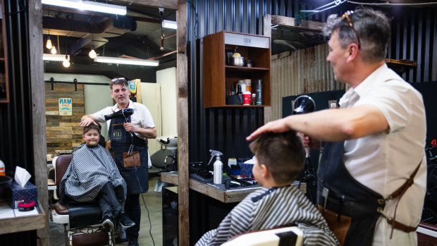 Soren Soltani gets a haircut at Barberiko in North Sydney by owner Nicolaos Vlahos.