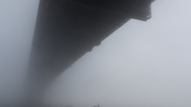 Fog envelopes the Sydney Harbour Bridge.