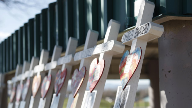 Crosses with the names of the victims of the massacre at Columbine High School nearly 20 years ago stand along a picnic site in the park before a vigil at the memorial.