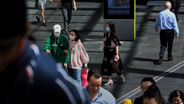 People with face masks walking along the street in Chatswood.