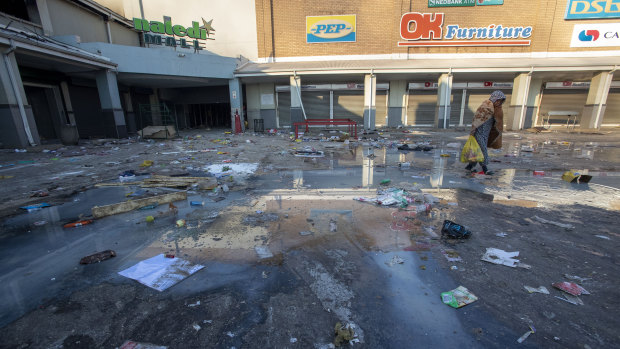 A young girl carrying groceries looted from a nearby shop, walks back home at Naledi shopping complex in Vosloorus, east of Johannesburg.