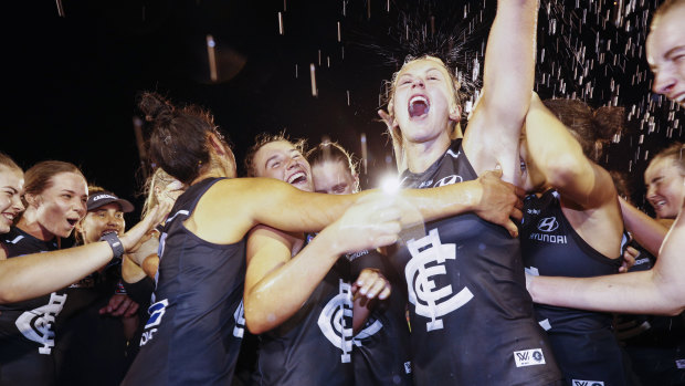 (L-R) Abbie McKay, Emerson Woods and Charlotte Wilson sing the team song after the Blues ran over the top of Collingwood.
