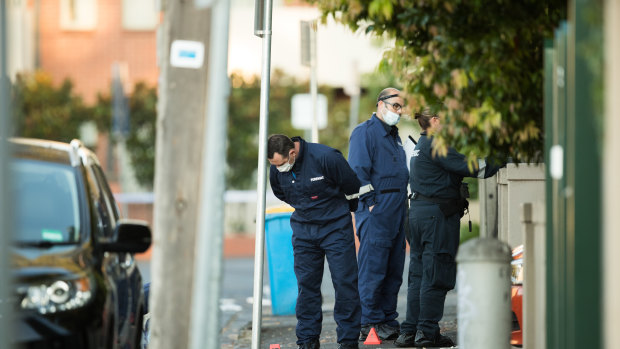 Forensic police inspect the scene in Walpole Street, Kew.