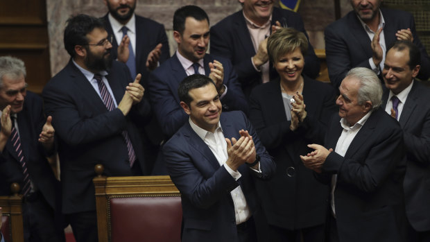 Greek Prime Minister Alexis Tsipras, centre, celebrates the announcement of the confidence vote results during a parliamentary session in Athens on Wednesday.