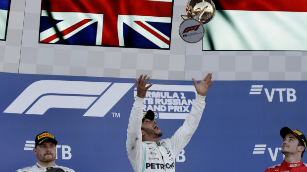 Cutting loose: Lewis Hamilton celebrates on the podium, as second-placed Valtteri Bottas (left) and third-placed Charles Leclerc (right) look on.