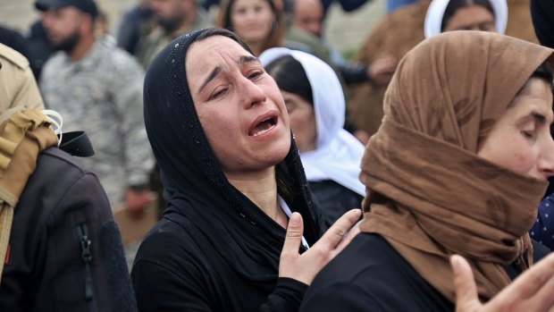 Iraqi Yazidi women mourn during the exhumation of a mass grave in Iraq's north-western region of Sinjar.