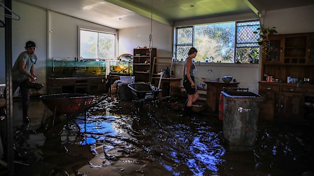 Residents clean a flood-damaged house in Taree.