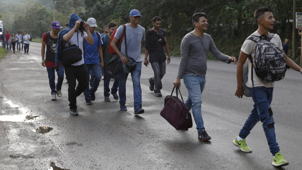 US-bound migrants walk along the roadside as they leave Cofradia, Honduras, on January 15. 