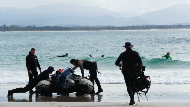 Police divers prepare to search water off Watego's Beach on Thursday. 