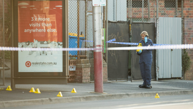 Police at a tram stop in Kew, near where a 59-year-old man was stabbed to death.