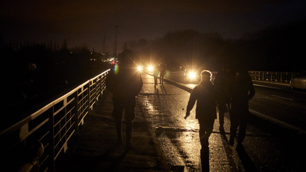Migrants walk down an autoroute near Dunkirk, France, on Friday. 