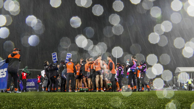 Snow falls on the ground during the game. between GWS and Hawthorn at Manuka Oval in Canberra on Friday night.