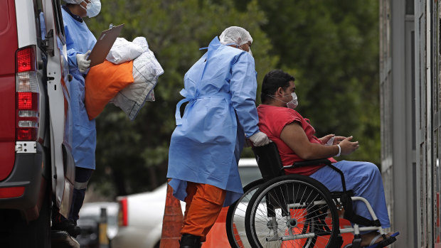 Healthcare workers push a patient suspected of having COVID-19 from an ambulance into a public hospital in Brasilia on the day the country passed 400,000 deaths from the disease.