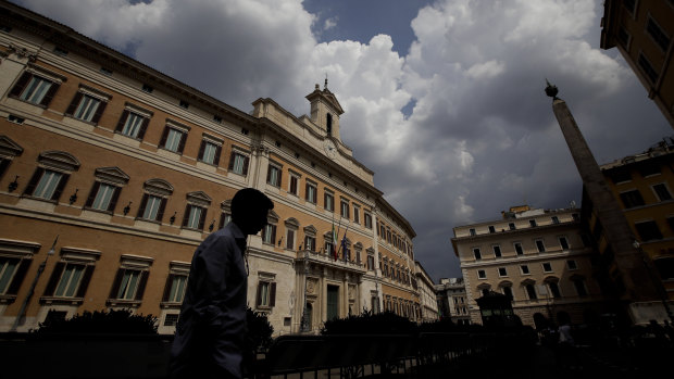 A man walks past Montecitorio palace, the Italian Lower Chamber. Italy is close to forming a new government after an online vote gave the go ahead for Five Star to join their former enemies in a coalition.
