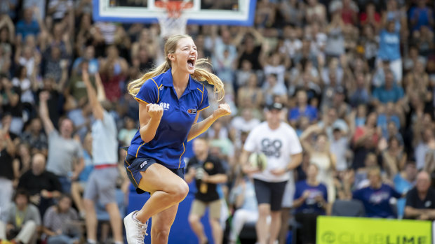 Teenager Caitlin Rowe reacts after sinking a half-court shot in front of nearly 5,000 people at half-time to win $10,000.