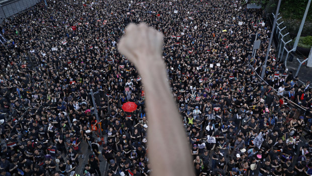 A protester clenches his fist as tens of thousands of protesters march on the streets to stage a protest against the unpopular extradition bill in Hong Kong.
