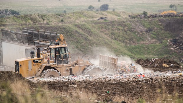 Trucks moving the burning waste back in February 2020.