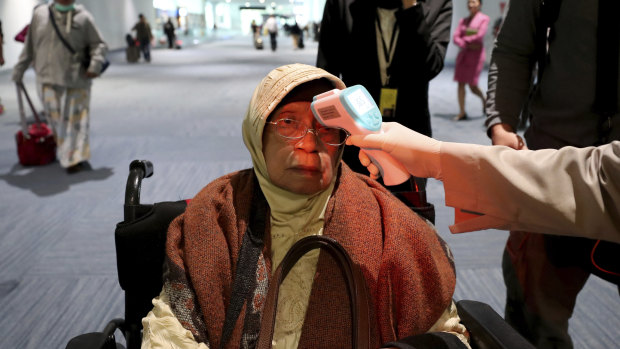 Temperature checks are used to monitor incoming passengers in Indonesia.