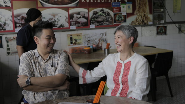 Penny Wong with her brother James, eating fishball congee on Thursday in Kota Kinabalu.