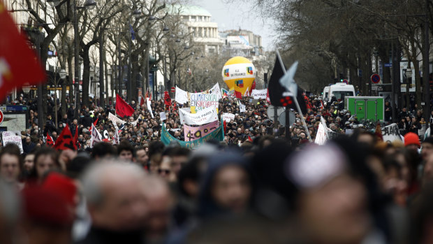 Demonstrators march to protest against pension reform plans in Paris on Tuesday, ahead of votes in the National Assembly.