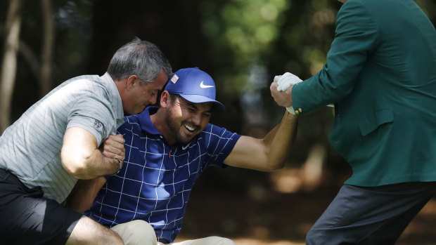Bad day: Jason Day is helped to his feet on the first day of the Masters.