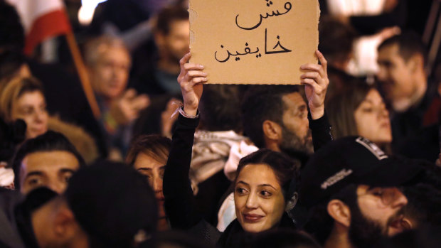 An anti-government protester holds an Arabic placard that reads:"We are not fearing" on Sunday.