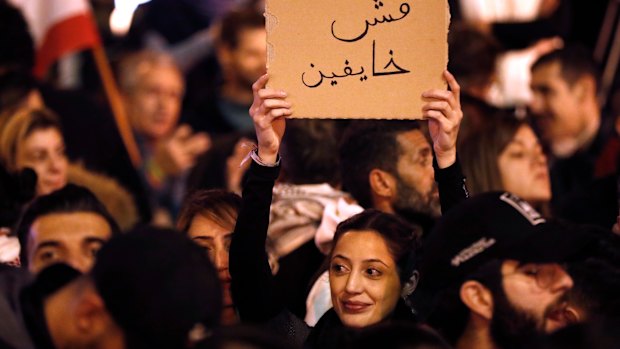 An anti-government protester holds an Arabic placard that reads:"We are not fearing" on Sunday.