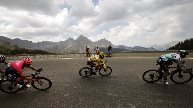 Julian Alaphilippe, wearing the overall leader's yellow jersey, rides with Rigoberto Uran, left, and Gregor Muhlberger, right, during stage 18 of the Tour de France.